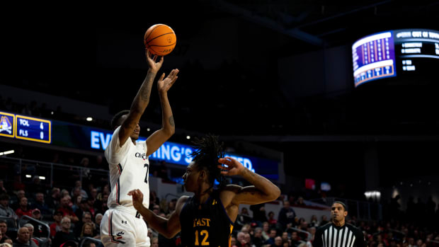 Cincinnati Bearcats guard Landers Nolley II (2) hits a 3-point basket over East Carolina Pirates guard Javon Small (12) in the first half of the NCAA men s basketball game at Fifth Third Arena in Cincinnati on Wednesday, Jan. 11, 2023. Ncaa Basketball Eastern Carolina Pirates At Cincinnati Bearcats