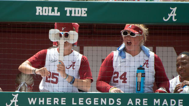 Alabama softball players Jordan Stephens (25) and KJ Haney (24) watch their teammates from the dugout.