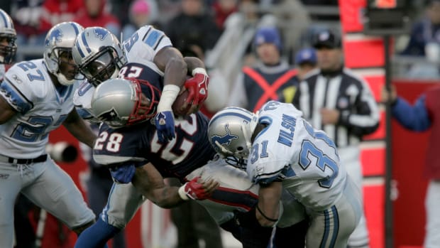 New England Patriots running back (28) Corey Dillon is tackled by Detroit Lions cornerback (31) Stanley Wilson and linebacker (50) Ernie Sims in the third quarter at Gillette Stadium. The Patriots came away with the win 28 - 21.
