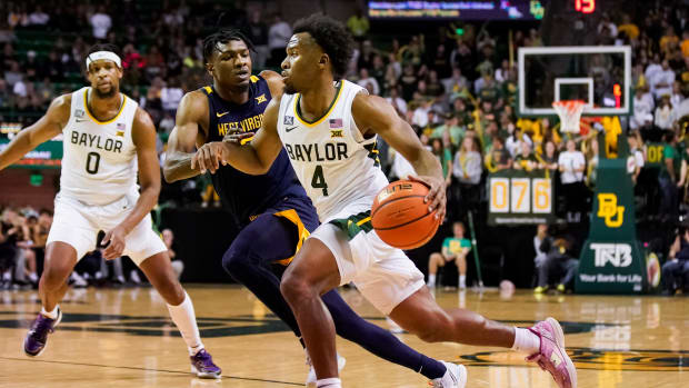 Feb 13, 2023; Waco, Texas, USA; Baylor Bears guard LJ Cryer (4) dribbles past West Virginia Mountaineers guard Joe Toussaint (5) during the second half at Ferrell Center.