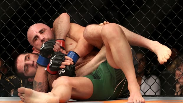 Islam Makhachev (red gloves) fights Alexander Volkanovski (blue gloves) during UFC 284 at RAC Arena.