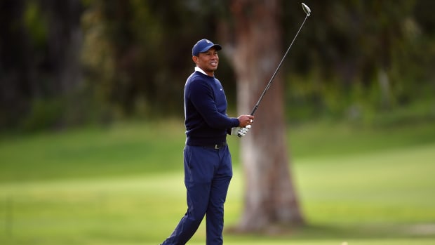 Pacific Palisades, California, USA; Tiger Woods plays his shot on the seventeenth hole fairway during the first round of The Genesis Invitational golf tournament.