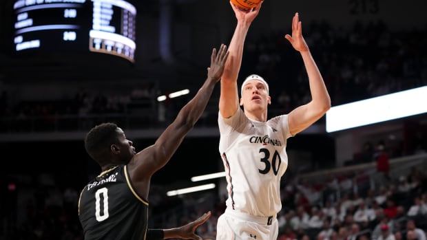 Cincinnati Bearcats forward Viktor Lakhin (30) rises for a shot as UCF Knights forward Lahat Thioune (0) defends in the first half of a college basketball game between the UCF Knights and the Cincinnati Bearcats, Saturday, Feb. 4, 2023, at Fifth Third Arena in Cincinnati. Ucf Knights At Cincinnati Bearcats Feb 4 0012