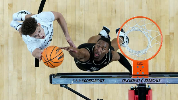 Cincinnati Bearcats guard Dan Skillings Jr. (0) rises to the basket as UCF Knights guard C.J. Kelly (13) defends in the first half of a college basketball game between the UCF Knights and the Cincinnati Bearcats, Saturday, Feb. 4, 2023, at Fifth Third Arena in Cincinnati. The Cincinnati Bearcats won, 73-64. Ucf Knights At Cincinnati Bearcats Feb 4 1196