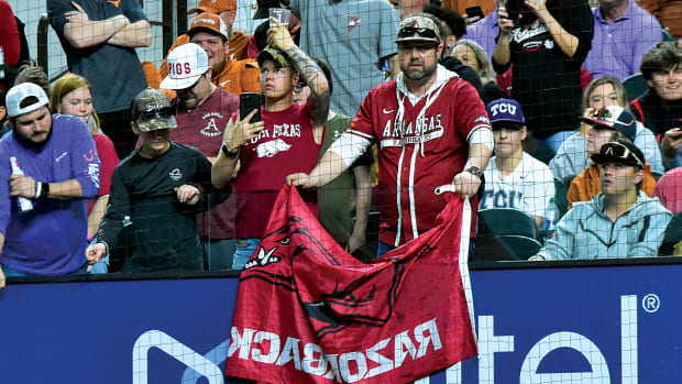 An Arkansas fan displays his Razorback flag in the midst of Texas and TCU fans in Arlington at Globe Life Field during a game between Texas and Arkansas.