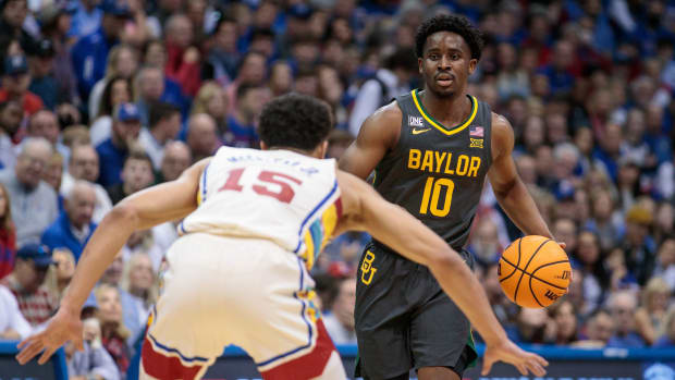 Feb 18, 2023; Lawrence, Kansas, USA; Baylor Bears guard Adam Flagler (10) looks to get around Kansas Jayhawks guard Kevin McCullar Jr. (15) during the first half at Allen Fieldhouse. Mandatory Credit: William Purnell-USA TODAY Sports