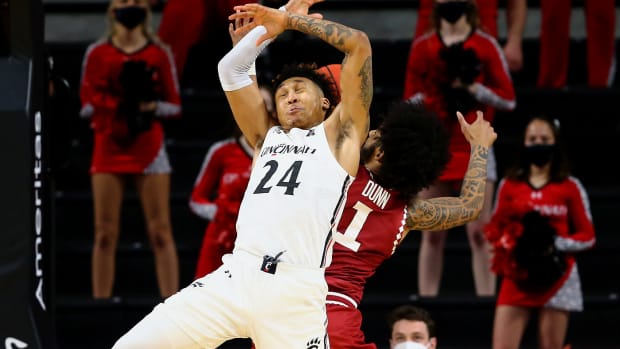 Cincinnati Bearcats guard Jeremiah Davenport (24) and Temple Owls guard Damian Dunn (1) compete for a rebound in the second half of an NCAA men's college basketball game, Friday, Feb. 12, 2021, at Fifth Third Arena in Cincinnati. The Cincinnati Bearcats won, 71-69. Temple Owls At Cincinnati Bearcats Feb 12
