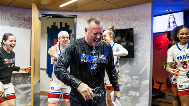 Kansas players celebrate Coach Brandon Schneider's 500th career win in the locker room.