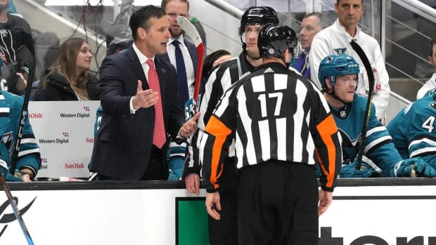 Sharks head coach David Quinn argues a call with the referees during a game.