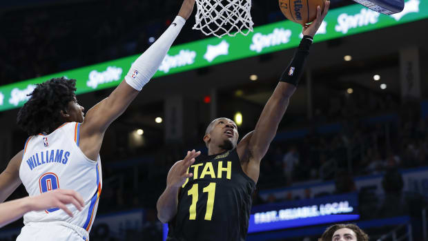Utah Jazz guard Kris Dunn (11) goes up for a basket as Oklahoma City Thunder forward Jalen Williams (8) defends during the second half at Paycom Center.