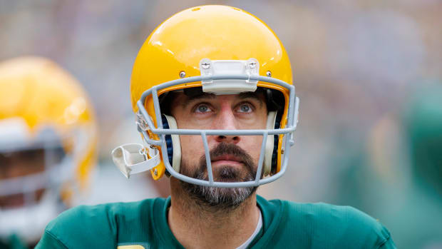 Aaron Rodgers looks up with a yellow helmet on