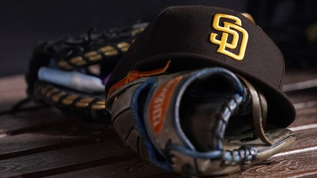 A general view of a San Diego Padres hat and glove in the dugout.