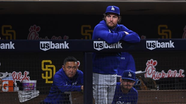 Los Angeles Dodgers starting pitcher Trevor Bauer (top) looks on from the dugout during the fifth inning against the San Diego Padres