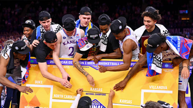 Apr 4, 2022; New Orleans, LA, USA; The Kansas Jayhawks place their name as national champions on the bracket after their win against the North Carolina Tar Heels in the 2022 NCAA men's basketball tournament Final Four championship game at Caesars Superdome.
