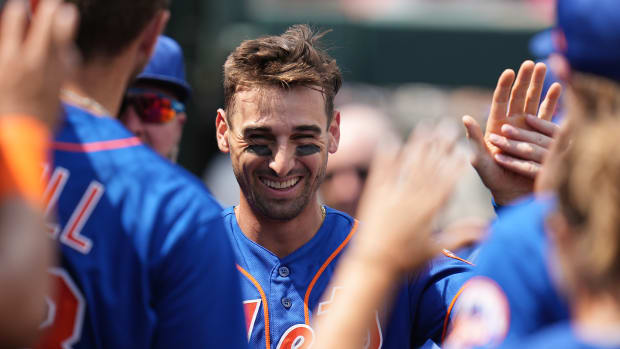 Mar 13, 2023; Jupiter, Florida, USA; New York Mets centerfielder Tim Locastro (83) is congratulated by teammates after scoring a run in the third inning against the Miami Marlins at Roger Dean Stadium.