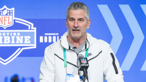 Carolina Panthers coach Frank Reich speaks into a microphone with the NFL combine logo behind him