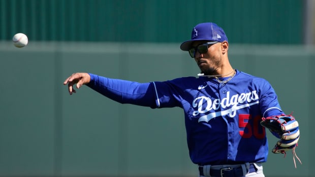Mookie Betts throws a ball toward third base in a spring training game for the Dodgers.
