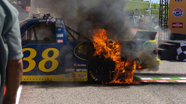 Fire spreads over Zane Smith's truck following his celebratory burnout after winning a NASCAR Truck Series race.