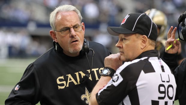 New Orleans Saints interim head coach Joe Vitt talks with line judge Mike Spanier (90) during a time out in the game against the Dallas Cowboys at Cowboys Stadium. The Saints beat the Cowboys 34-31 in overtime.