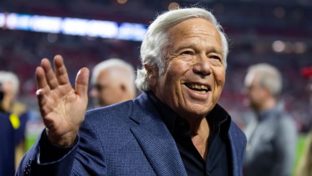 Patriots owner Robert Kraft smiles and waves on the field