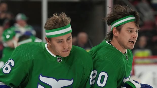 Hurricanes players Sebastian Aho and Teuvo Teravainen warm-up before a game vs. the Bruins in throwback Whalers uniforms.