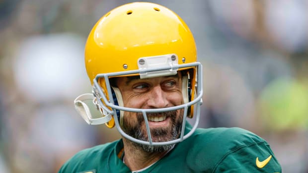Aaron Rodgers smiles while warming up for the Packers