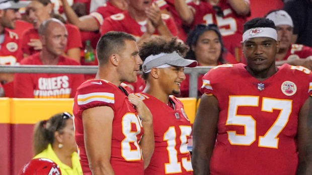 Aug 27, 2021; Kansas City, Missouri, USA; Kansas City Chiefs tight end Travis Kelce (87) and quarterback Patrick Mahomes (15) and offensive tackle Orlando Brown (57) watch play on the sidelines against the Minnesota Vikings during the game at GEHA Field at Arrowhead Stadium.