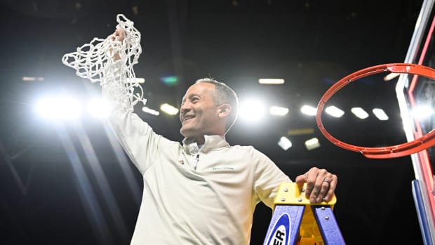 North Texas head coach Grant McCasland cuts down the nets following a NIT championship victory.
