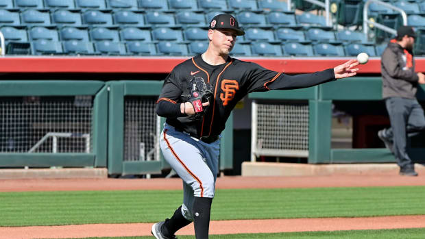 SF Giants pitcher Kyle Harrison throws to first base during a drill at spring training. (2023)