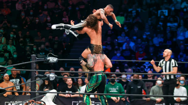 Jungle Boy, on the shoulders of Luchasaurus, catches a leaping Isiah Kassidy during the AEW Dynamite - Beach Break taping