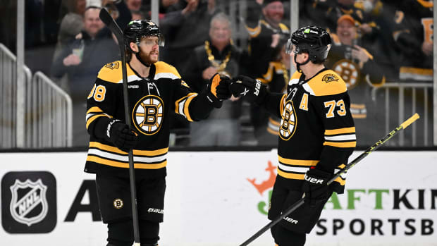 Boston Bruins right wing David Pastrnak (88) reacts with defenseman Charlie McAvoy (73).
