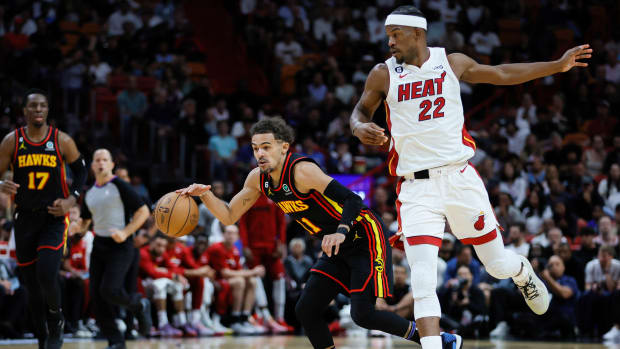 Atlanta Hawks guard Trae Young dribbles past Miami Heat forward Jimmy Butler.