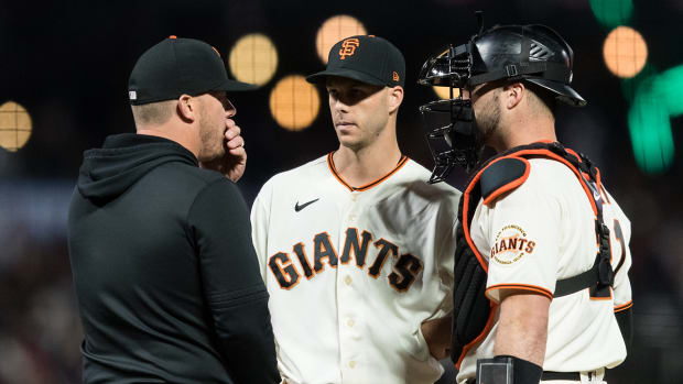 San Francisco Giants pitching coach Andrew Bailey (84) talks to relief pitcher Taylor Rogers (33) and catcher Joey Bart (21) against the Los Angeles Dodgers.