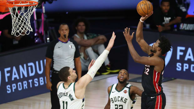 Miami Heat forward Jimmy Butler (22) shoots over Milwaukee Bucks center Brook Lopez (11) and forward Khris Middleton (22)