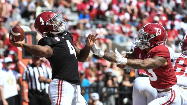 White team quarterback Jalen Milroe (4) throws a pass as he is pressured by Crimson team defensive back Malachi Moore (13) at Bryant-Denny Stadium.