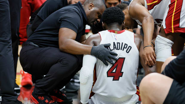 Heat guard Victor Oladipo (4) is checked on after an injury in the fourth quarter against the Bucks during game three of the 2023 NBA Playoffs at Kaseya Center.