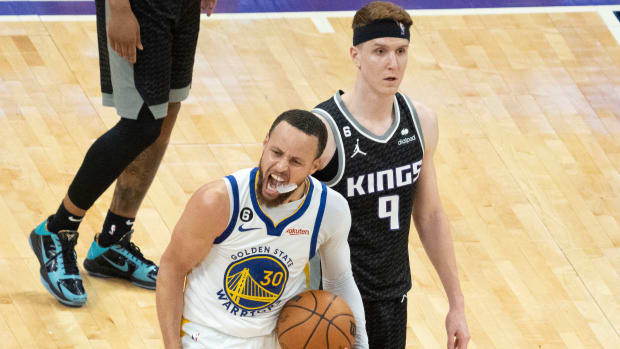 Warriors guard Stephen Curry celebrates in front of Kings guard Kevin Huerter during the fourth quarter of Game 7