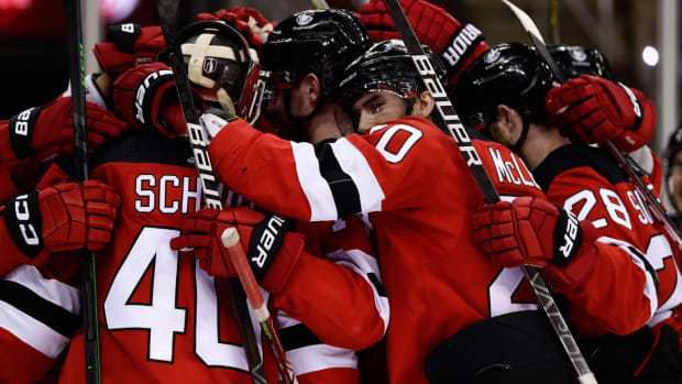 New Jersey Devils center Michael McLeod (20) hugs goaltender Akira Schmid (40) after defeating the New York Rangers in Game 7 of an NHL hockey Stanley Cup first-round playoff series Monday, May 1, 2023, in Newark, N.J. (AP Photo/Adam Hunger)