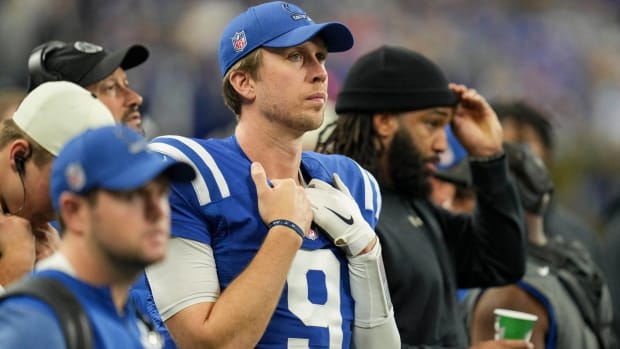 Colts quarterback Nick Foles looks on from the sidelines without a helmet during a game.