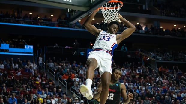 Kansas' Ernest Udeh Jr. hangs on the rim after drunking the ball during the NCAA men's basketball tournament first round match-up between Kansas and Howard, on Thursday, March 16, 2023, at Wells Fargo Arena, in Des Moines, Iowa.