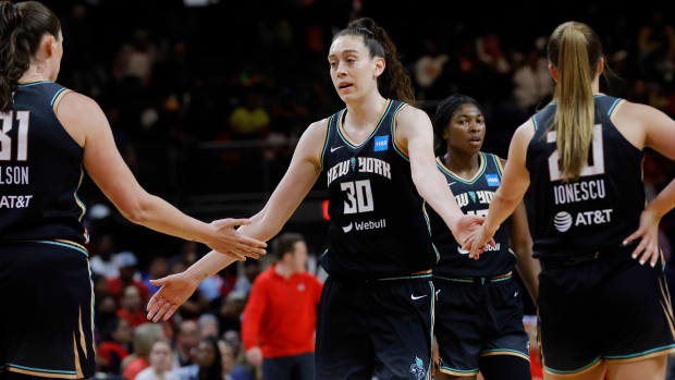 New York Liberty forward Breanna Stewart gives high fives to two teammates