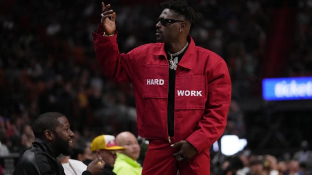 Antonio Brown stands up and reacts while watching a game between the Heat and Celtics.