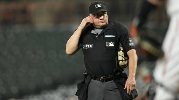 MLB umpire Jeff Nelson talks with the replay review center during a game.