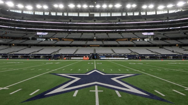 The Dallas Cowboys logo in the middle of AT&T Stadium in an empty stadium before a game.