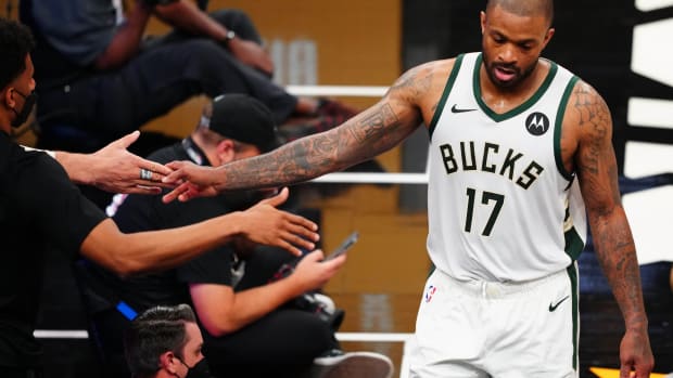 Milwaukee Bucks forward P.J. Tucker (17) is greeted by the bench