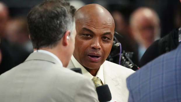 NBA analyst Charles Barkley speaks into a mike while participating in a broadcast.