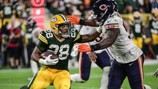 Sep 18, 2022; Green Bay, Wisconsin, USA; Green Bay Packers running back A.J. Dillon (28) tries to break a tackle by Chicago Bears defensive tackle Justin Jones (93) in the fourth quarter at Lambeau Field.