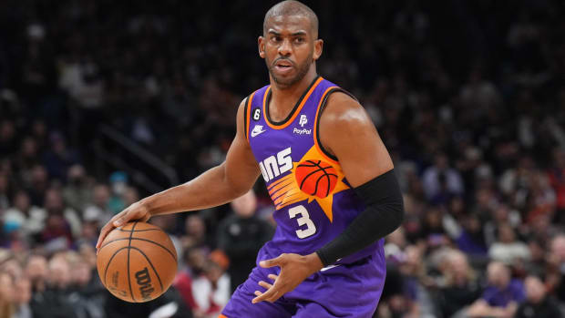 Suns point guard Chris Paul dribbles a ball in a game.