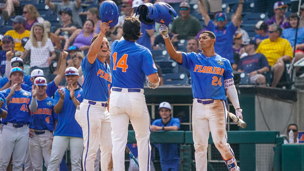 Gators first baseman Jac Caglianone (14) celebrates with center fielder Wyatt Langford (36) and shortstop Josh Rivera (24) after hitting a two-run home run against LSU during the eighth inning at Charles Schwab Field Omaha.