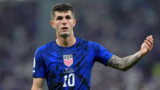 U.S. soccer forward Christian Pulisic holds up his left arm after a play during a World Cup match vs. Iran.